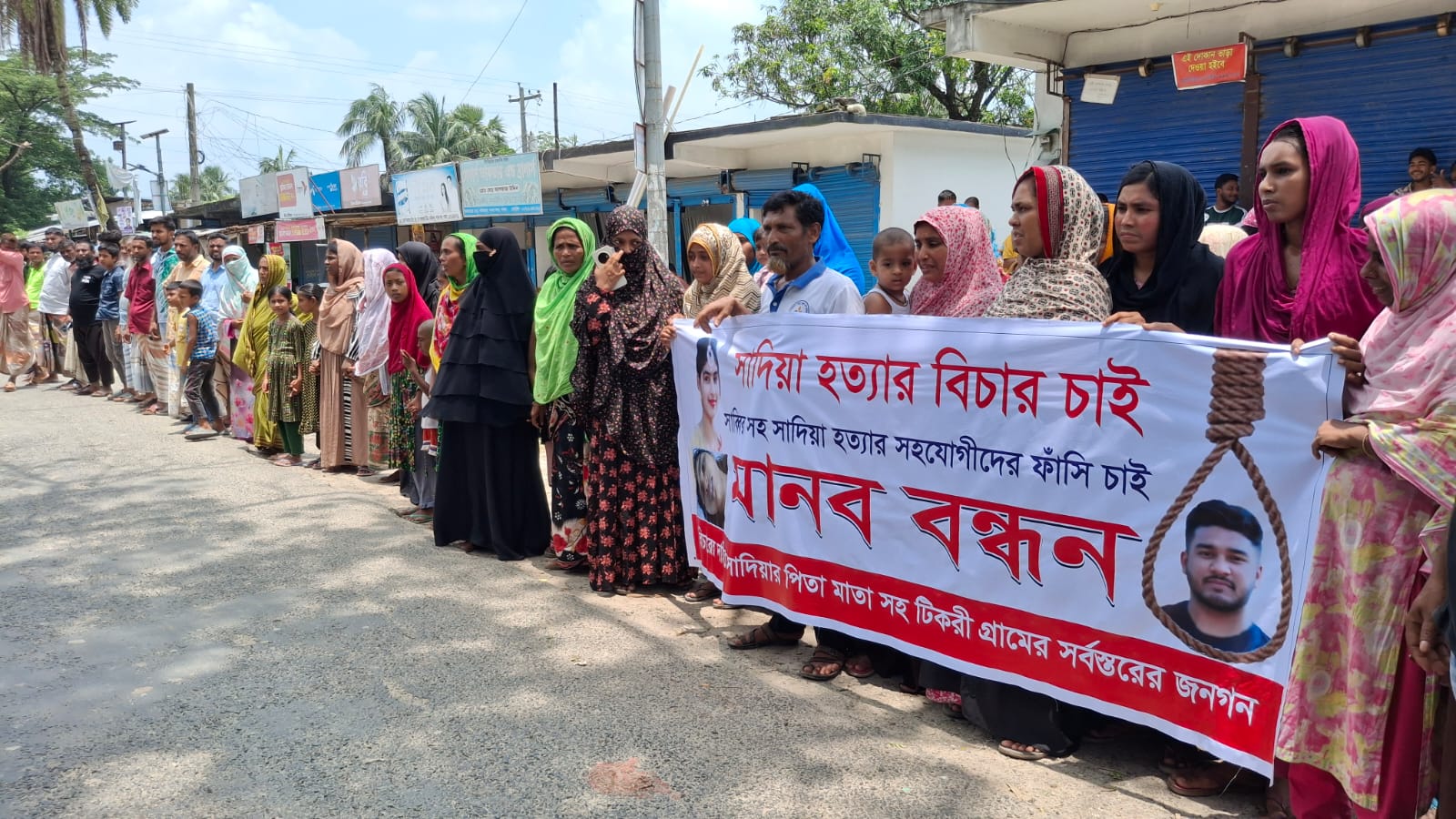 গৃহবধূ সাদিয়া হত্যার বিচার দাবিতে মানববন্ধন করে স্বজন ও এলাকাবাসী। শনিবার দুপুরে পাবনা সদর উপজেলার দাপুনিয়া আক্তারের ঢাল নামক স্থানে। পাবনায় গৃহবধূ সাদিয়া হত্যার বিচার দাবি: আসামি প্রকাশ্যে ঘুরছে অভিযোগ পরিবারের